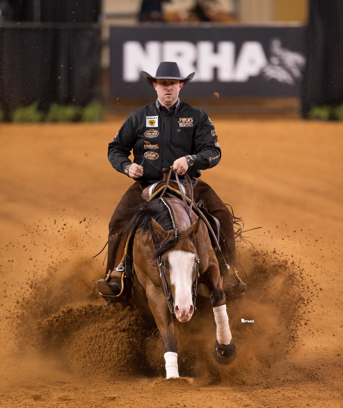 Josh Tishman and his horse doing a sliding stop during a reining competition