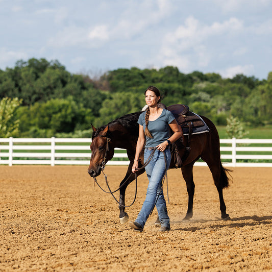 Woman leading horse in an arena