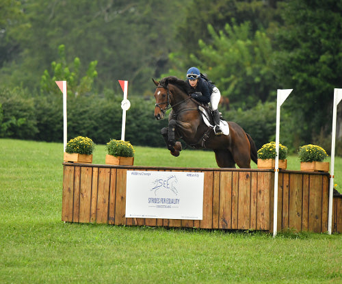 horse and rider jumping outside